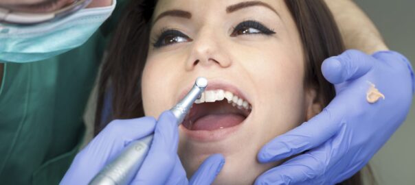 Dentist cleaning a patient's teeth.